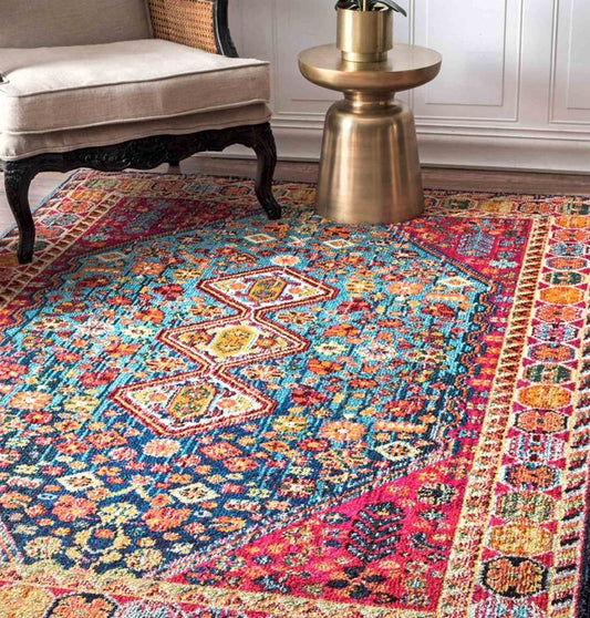 Colorful patterned rug in a room with a chair and small table.