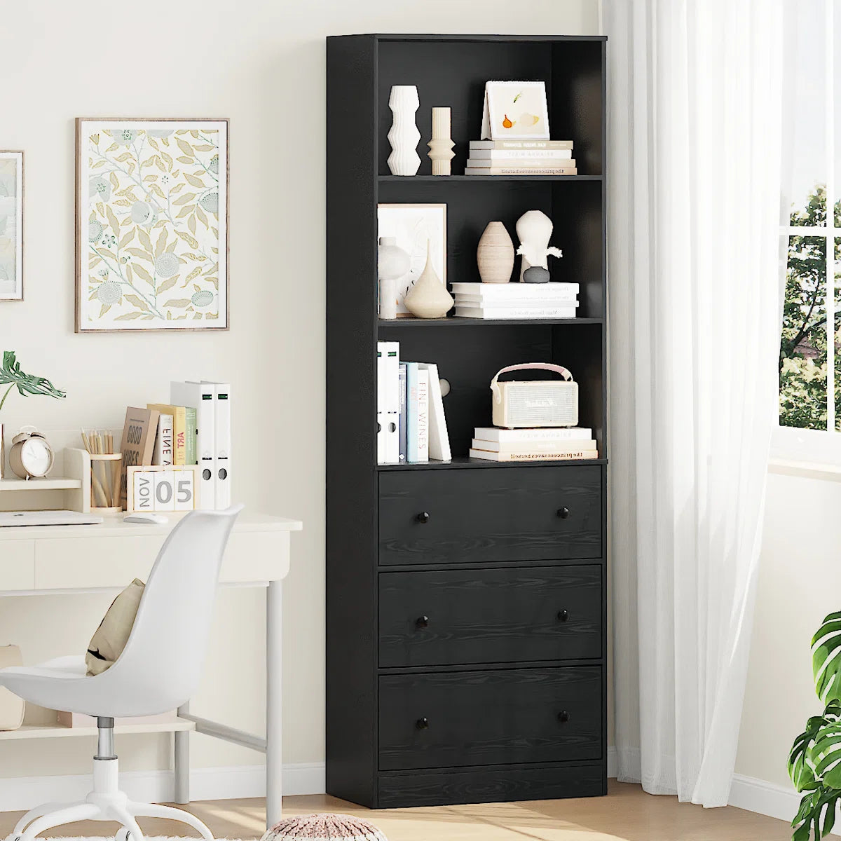 Black bookshelf with decorative items in a room with a desk and window.