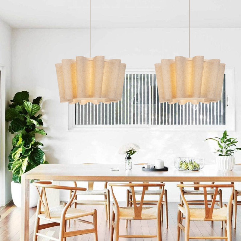 Dining room with wooden table and chairs, modern pendant lights, and plants.