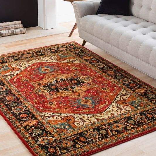 Decorative rug with intricate patterns on a wooden floor next to a gray sofa.