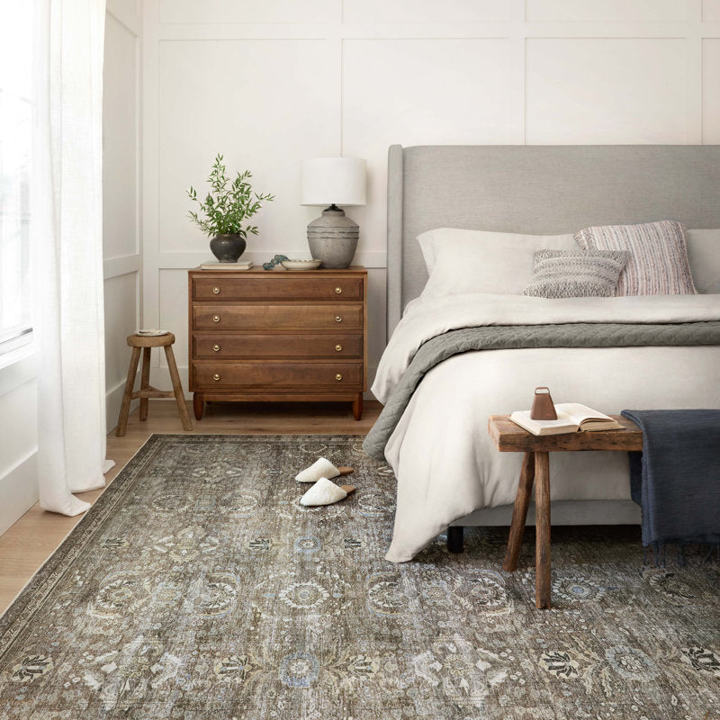 Bedroom with a gray rug, wooden nightstands, and a bed with white bedding.
