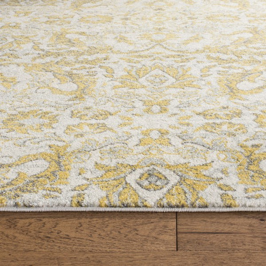 Close-up of a patterned rug with yellow and gray design on wooden floor.