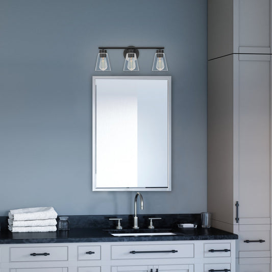 Bathroom vanity with mirror, light fixture, and towels against a gray wall.