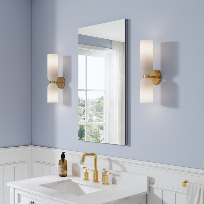 Bathroom with a mirror, sink, and wall lights on a light blue wall.